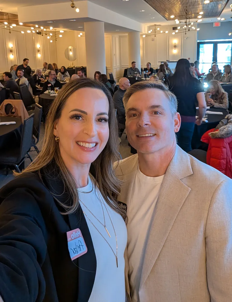 Craig and Amber at a Calgary real estate investor meetup, room full of attendees behind them