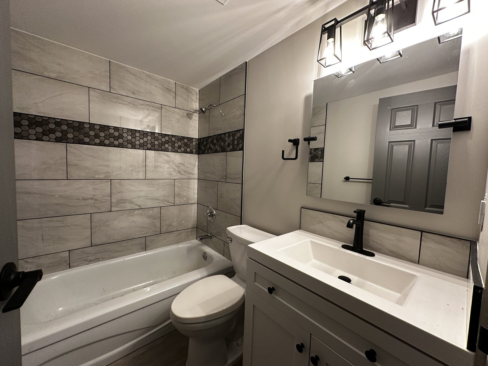 Renovated bathroom at Upland — tiled tub surround with mosaic accent band
